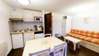 a kitchen with a table and a couch in a room at Appartement 6 places au cœur de Luz Saint sauveur in Luz-Saint-Sauveur