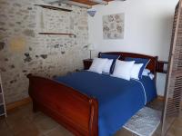 a blue bed with white pillows in a bedroom at La charentaise ch d&#39;hôtes ,Studio in Chérac