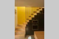 ein Wohnzimmer mit einer Treppe und einer gelben Wand in der Unterkunft Maison Joli Soir à Ambleteuse in Ambleteuse