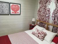 a bedroom with a bed with a red and white bedspread at Complejo Rural Huerta Grande in Algeciras