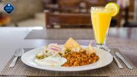 un plato de comida y un vaso de jugo de naranja en Hotel Maioris Guadalajara, en Guadalajara