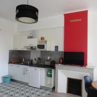 a kitchen with white cabinets and a red wall at Villa Zola in Aix-en-Provence