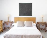 a bedroom with a bed with two tables and a chalkboard at Hotel Hacienda Montenmedio in Vejer de la Frontera