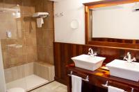 a bathroom with two sinks and a shower at Hotel Hacienda Montenmedio in Vejer de la Frontera