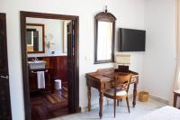 a bathroom with a desk and a sink and a mirror at Hotel Hacienda Montenmedio in Vejer de la Frontera