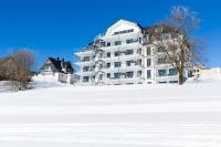 a large white apartment building in the snow at Astenblick Apartments Winterberg with sauna in Winterberg