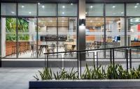 Un vestíbulo de un edificio con mesas y sillas. en PLAAI Plus Hotel Rayong, en Rayong