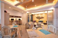 a dining room with tables and chairs and a couch at Absolute Sanctuary in Choeng Mon Beach