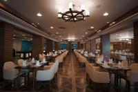 Un restaurante con mesas y sillas y una lámpara de araña. en Cancun Sokhna Resort & Villas, en Ain Sokhna