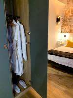 a room with a closet with white clothes and a bed at Luxe et Calme en Hyper Centre - La Cour des Bois in Lyon