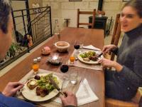 zwei Personen sitzen an einem Tisch mit Teller Essen in der Unterkunft La Grange Dîmière, près de Tours in Saint-Genouph