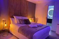 a bedroom with a large bed with purple lighting at Appart&amp;Spa Devosge in Dijon