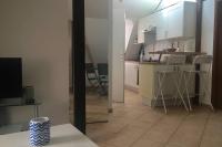 a kitchen with white cabinets and a table and chairs at Appartement de charme rue du Château in Auray