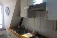 a kitchen with a sink and a clock on the wall at Appartement de charme rue du Château in Auray