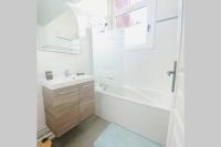 a bathroom with a tub and a sink and a mirror at Proche Golf Appartement 4pers avec parking piscine tennis in Neufchâtel-Hardelot