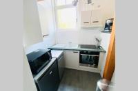 a small kitchen with a sink and a microwave at Proche Golf Appartement 4pers avec parking piscine tennis in Neufchâtel-Hardelot