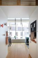 a living room with a table and a large window at Zoku Copenhagen in Copenhagen
