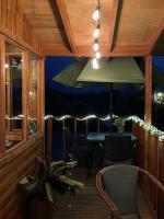 porche con mesa, sillas y sombrilla en Villarreal Lodge Hotel Ecológico, en Totolapan