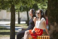 deux femmes assises sur un banc portant des écouteurs dans l&#39;établissement Les Chambres de l&#39;Abbaye, à Saintes