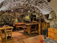 un restaurante con mesas de madera y una pared de piedra en Logis Hôtel & Spa Les Autanes, en Ancelle