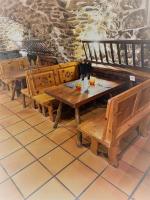 una fila de mesas y bancos de madera en un restaurante en Logis Hôtel & Spa Les Autanes, en Ancelle