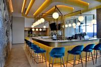 un bar con sillas azules en un restaurante en Courtyard Hotel Waterfall City, en Midrand