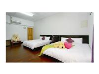 two beds with stuffed animals on them in a room at Phoenix Walkway Homestay in Taitung City
