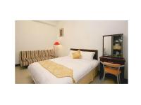 a bedroom with a bed and a chair and a table at Phoenix Walkway Homestay in Taitung City