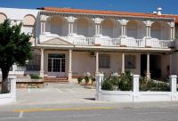 un edificio con una valla blanca delante de él en Hostal La Noria, en Ruidera