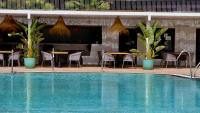 a pool with tables and chairs next to a restaurant at Casas Heddy, Well-being Resort in Puerto del Carmen