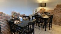 een eetkamer met zwarte tafels en stoelen en een bakstenen muur bij Hotel Senador Distributed by Ameris - Quedas do Iguaçu - Paraná in Quedas do Iguacu