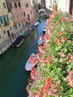 a group of boats in a canal with flowers at Antica Locanda Montin in Venice