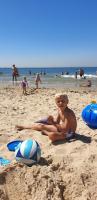 a young boy sitting on a beach with a volley ball at Rijksmonument Havenzicht, met zeezicht, ligging direct aan zee en centrum in Vlissingen