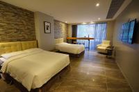 a bedroom with two beds and a brick wall at 3 Door Hotel in Tainan