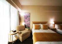 a hotel room with a bed and a chair at Chiayi Maison de Chine Hotel in Chiayi City