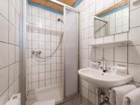 a white bathroom with a sink and a shower at Pension Konrad in Söll