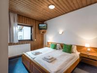 a bedroom with a large white bed with green pillows at Pension Konrad in Söll