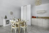 a white kitchen with a wooden table and chairs at Une nouvelle adresse de vacances face a la mer in Pléneuf-Val-André