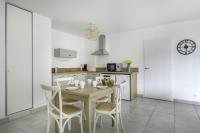 a kitchen with a wooden table and chairs in a room at Une nouvelle adresse de vacances face a la mer in Pléneuf-Val-André
