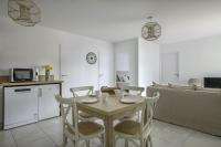 a kitchen and dining room with a table and chairs at Une nouvelle adresse de vacances face a la mer in Pléneuf-Val-André
