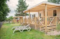 une cabine avec une terrasse et deux chaises dans la cour dans l&#39;établissement Camping RCN La Ferme du Latois, à Coëx