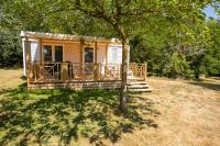 une petite maison avec une véranda et un arbre dans l&#39;établissement Camping RCN La Ferme du Latois, à Coëx