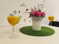 einen Tisch mit einer Vase Blumen und zwei Gläsern in der Unterkunft Apartman i studio apartman Vitana in Garešnica