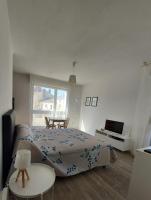 a bedroom with a bed and a table and a window at Studio Saint Roch in Mont-de-Marsan