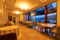 a restaurant with tables and chairs and large windows at HOTEL HIMALAYA SEA in Ito