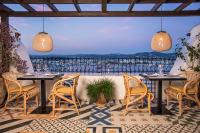 Un patio con mesas y sillas y vista al mar. en Hotel La Torre del Canonigo - Small Luxury Hotels, en Ibiza