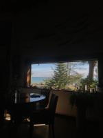 a table and chairs in a dark room with a large window at Bridge12th B&amp;B in Yanliau