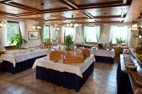 Un comedor con mesas y sillas blancas. en Parkhotel Sonnenhof, en Oberammergau