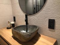 a bathroom with a large stone bowl sink in front of a mirror at Vakantiehuis Onverbloemd in Tielt