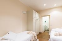 a white bedroom with two beds and a closet at Agave in Città in Livorno